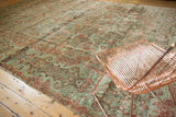 Distressed American Sarouk carpet with faded teal, red floral motifs, textured pile.