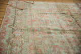 Distressed pile showing faded Rococo style floral patterns in red and dusty teal.