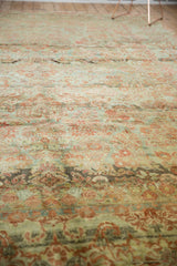 Distressed American Sarouk carpet texture, soft floral patterns in faded red and dusty teal.