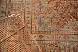 Vintage Joshegan carpet's distressed texture, showing red and pale blue lattice field pattern.