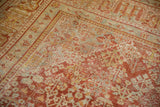 Intricate lattice design on a distressed vintage Joshegan carpet in cinnabar and pale blue.