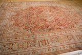Distressed Joshegan carpet showcasing its cinnabar red field, pale blue lattice, and diamond medallion.