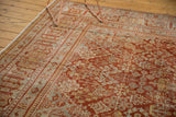 Distressed cinnabar red Joshegan carpet with pale blue and ivory floral lattice pattern.