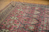 Decorative distressed Tabriz carpet detail: raspberry red field with navy floral palmettes.