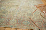 Angled view of a vintage Tabriz rug's low pile, showing its faded Safavid design in muted blue and rose.