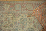 Worn texture of a vintage Persian Tabriz with dusty rose, beige, and slate blue floral motifs.