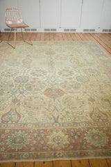Angled view of a distressed Tabriz rug, showcasing its soft patina and muted floral lattice design.