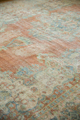 Worn pile of distressed Mahal carpet, showing brick, powder blue, and ivory Rococo motifs.