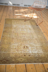 Distressed Hamadan rug with Samovar / Turtle border, showing worn gold, ivory, and olive tones.