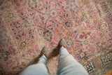 Distressed pink Sparta rug with faded palmettes and blue seasonal motifs underfoot.