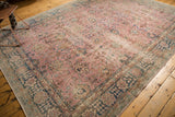 Distressed pink and indigo border of a vintage Sparta rug with palmette and vine motifs.