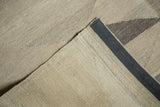 Hand woven Kilim corner showing flatweave texture, ivory, beige, and dark gray selvage.