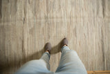 New Kilim carpet with abrashed ivory, silver, and beige striations from a standing view.