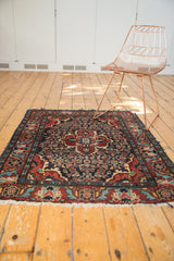 Traditional Persian Dargezine rug corner: Herati motif, madder red border, tattered fringe.