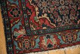 Vintage Dargezine rug's madder root red border, navy Herati pattern, and tattered fringe.