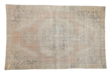 Distressed vintage Oushak rug with faded oversized medallion in beige, apricot, and slate blue.