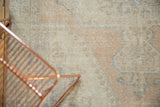 Textural close-up of a vintage distressed Oushak rug, showing beige, apricot, and dusty blue tones.