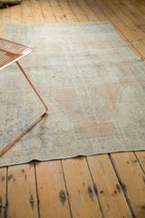 Distressed Oushak rug texture, showing wear to foundation, with muted apricot and blue tones.