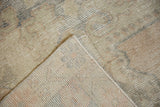 Vintage Oushak rug showing distressed pile, exposed foundation, and hand-knotted backing.