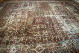 Paneled design and textured wear on distressed Bakhtiari rug, showing wine red and sky blue.