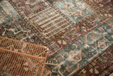 Distressed Bakhtiari carpet detail: worn pile, exposed foundation, red and blue paneled motifs.