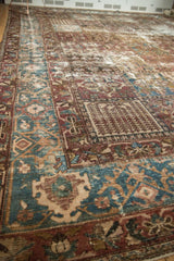 Worn, distressed Bakhtiari carpet showing paneled tree of life motifs, wine red, and blue.