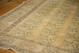 Distressed Oushak rug field with faded saffron, blue-green floral motifs, worn pile.