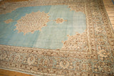 The roundel medallion and watery blue abrashed field of a distressed vintage Persian Tabriz carpet.