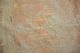 Vintage distressed Oushak carpet with faded pale peach and ivory geometric motifs.