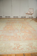 Textured distressed vintage Oushak carpet with faded pale peach and ivory colors.