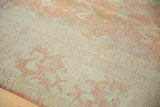 Distressed vintage Oushak rug, with worn texture, pale peach patterns, and ivory ground.