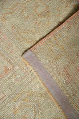 Distressed vintage Oushak pile with pale peach patterns, secure selvage, and reverse foundation.