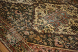 Afshari influenced floral patterns on a distressed vintage Bakhtiari rug in pale gold and dusty teal.