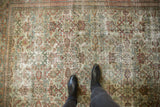 Distressed Mahal carpet with allover Herati motif, faded ivory, terracotta, and green colors underfoot.
