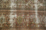 Distressed texture of a vintage Mahal carpet fragment, showing foundation wear and terracotta Herati motif.