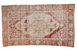 Distressed Vintage Oushak rug with faded cherry red concentric medallion and beige floral field, 4'8