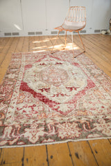 Distressed vintage Oushak rug border with cherry red floral pattern, worn texture.