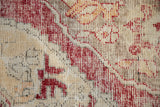 Distressed vintage Oushak rug pile, with cherry red motifs and visible beige foundation.