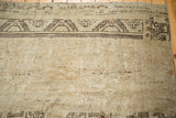 Distressed antique ivory Oushak rug with prominent chocolate brown geometric border.