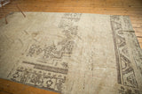 Decorative distressed vintage Oushak rug with antique ivory and chocolate brown tribal motifs.