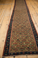 Antique Caucasian runner: navy border, saffron field, repeating germinating plant motif, pile wear.
