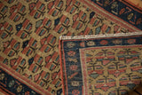 Geometric plant motif on antique Caucasian rug pile with wear, fringe, and hand-knotted foundation.