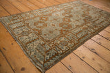 Visible wear on a distressed Belouch rug, bronze rams horn, and tribal tree border.