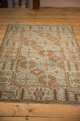 Distressed vintage Persian Belouch rug corner with rams horn motifs in pale bronze and ivory.