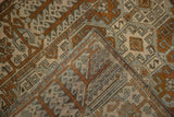 Distressed vintage Belouch rug with geometric patterns, revealing worn pile and hand-knotted foundation.