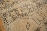 Distressed pile of the vintage Serab rug showing muted ivory, blue-green abrash, and geometric patterns.