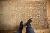 Distressed Belouch rug with even wear, faint foundation, and light ivory boteh motifs.