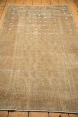 Distressed beige Belouch rug pile, showcasing even wear and a mostly intact side selvage.