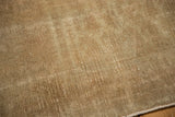 Worn pile texture of a Vintage Distressed Belouch rug in light beige and ivory.