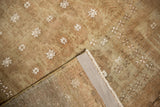 Distressed vintage Belouch rug corner, visible wear and repeating motifs on hand-knotted foundation.